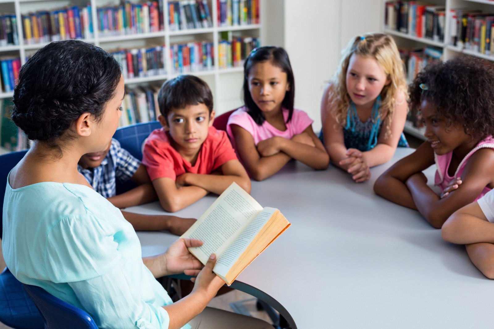 Teacher reading book at children look at her Teacher reading book at children look at her
